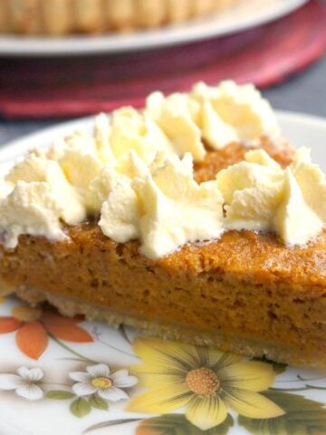 A slice of cream-decorated sweet potato pie