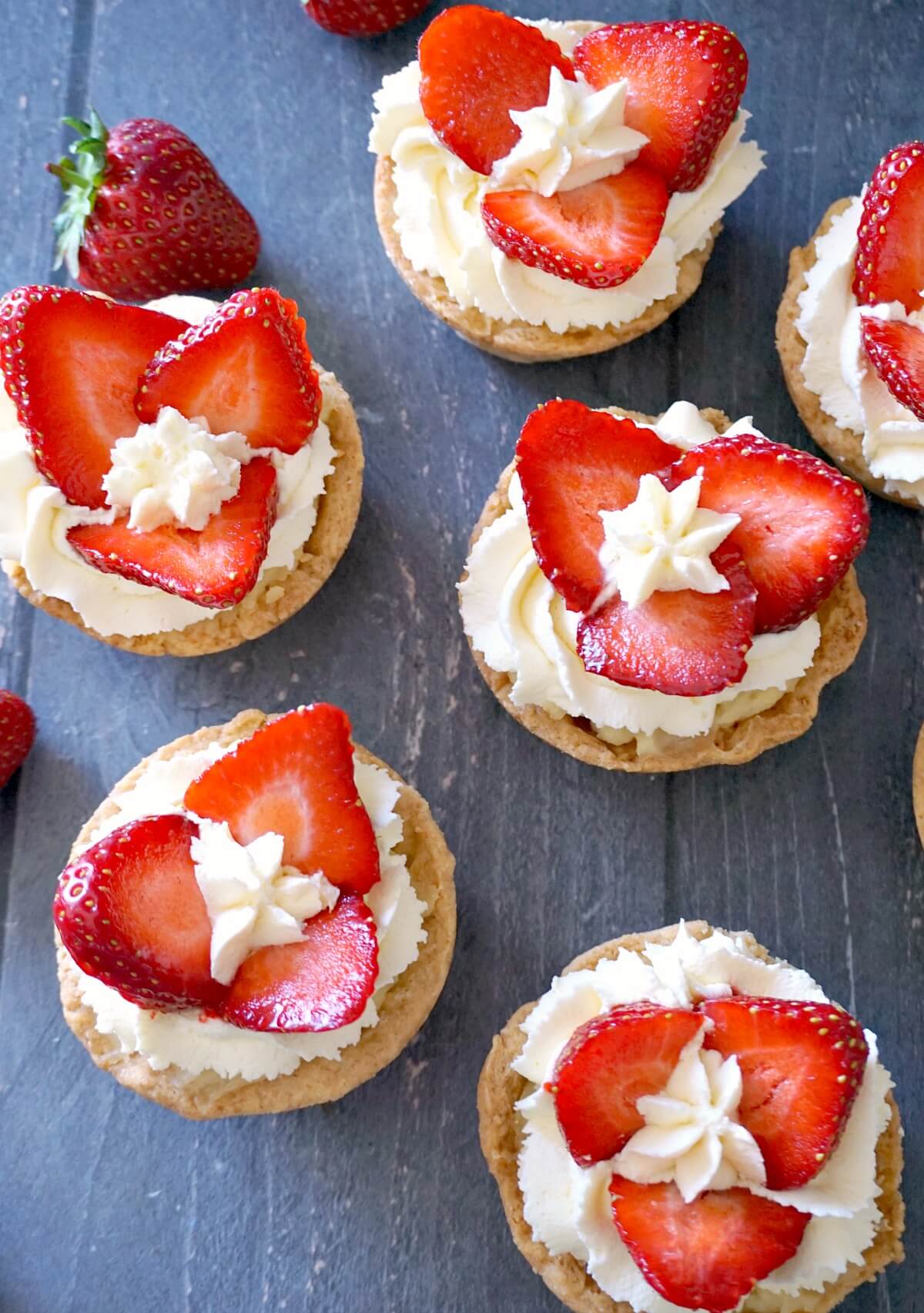 Overhead shoot of 6 strawberry and cream tartlets