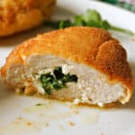 Half of a chicken Kiev on a white plate.