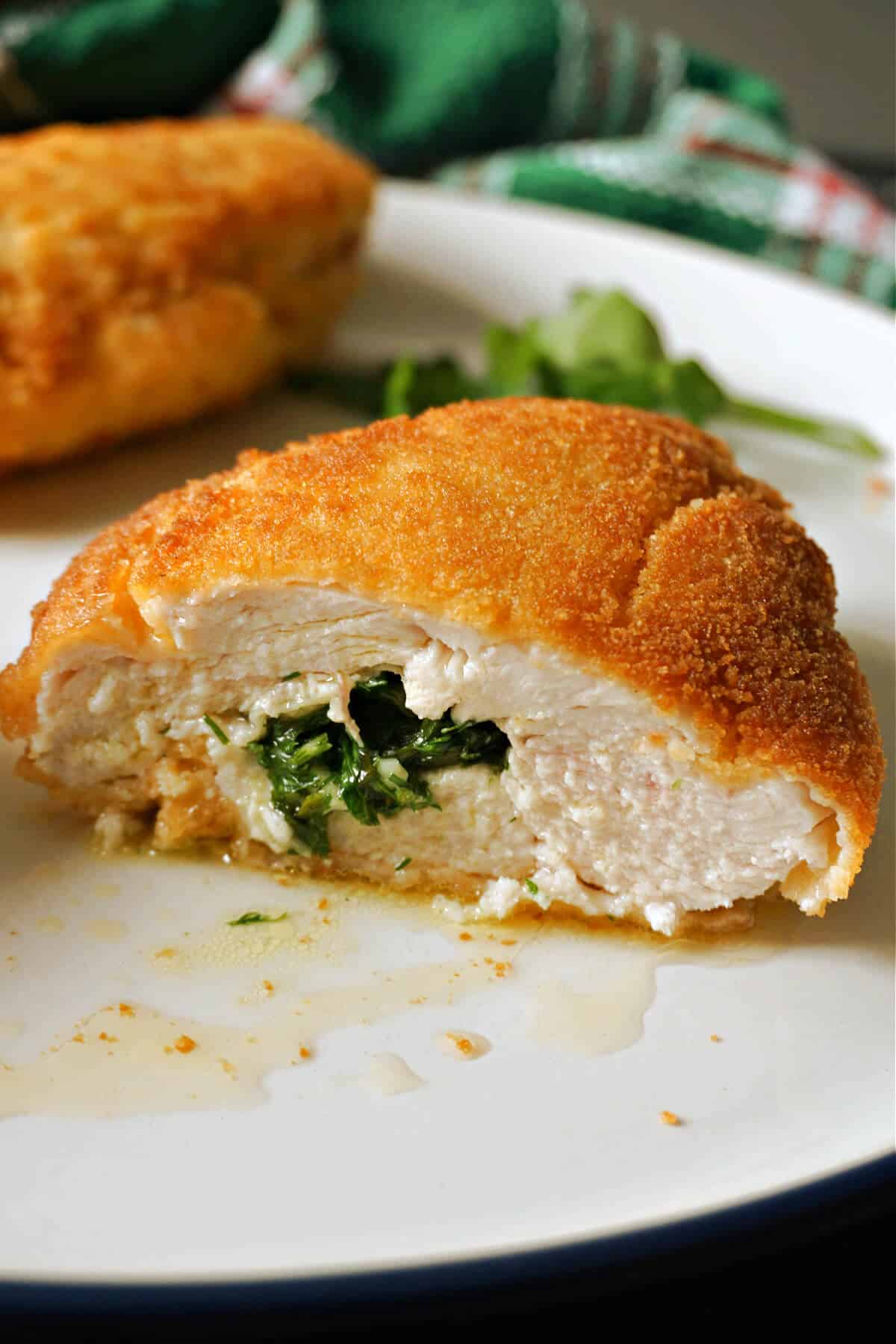 Half of a chicken kiev on a white plate.