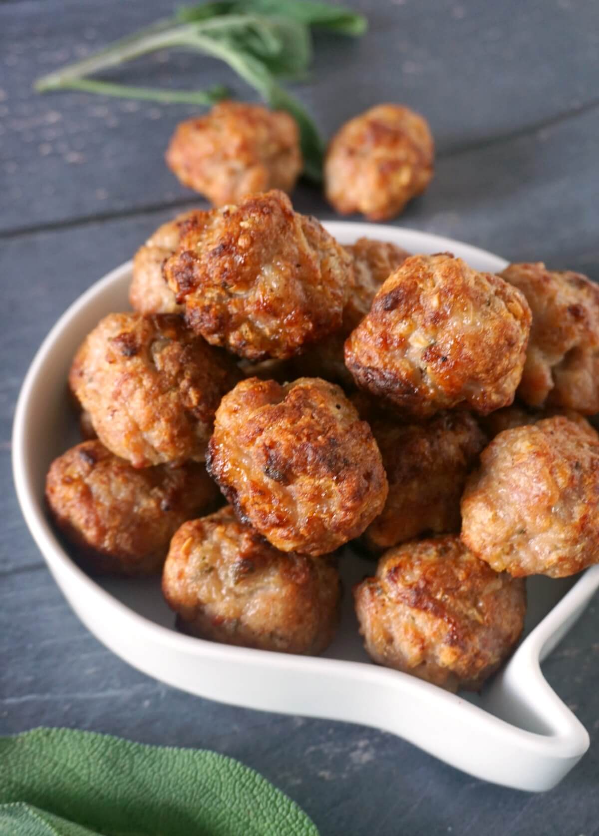 A white bowl with sausage stuffing balls.