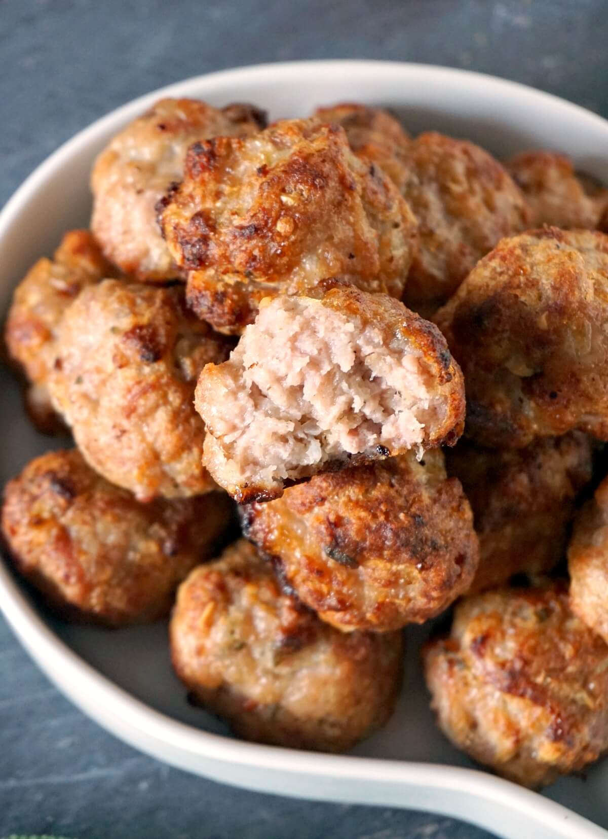 Close-up shoot of a white bowl with sausage stuffing balls.