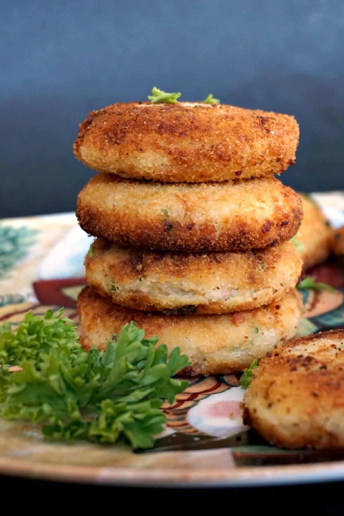 A stack of 4 patties with fresh parsley next to it.