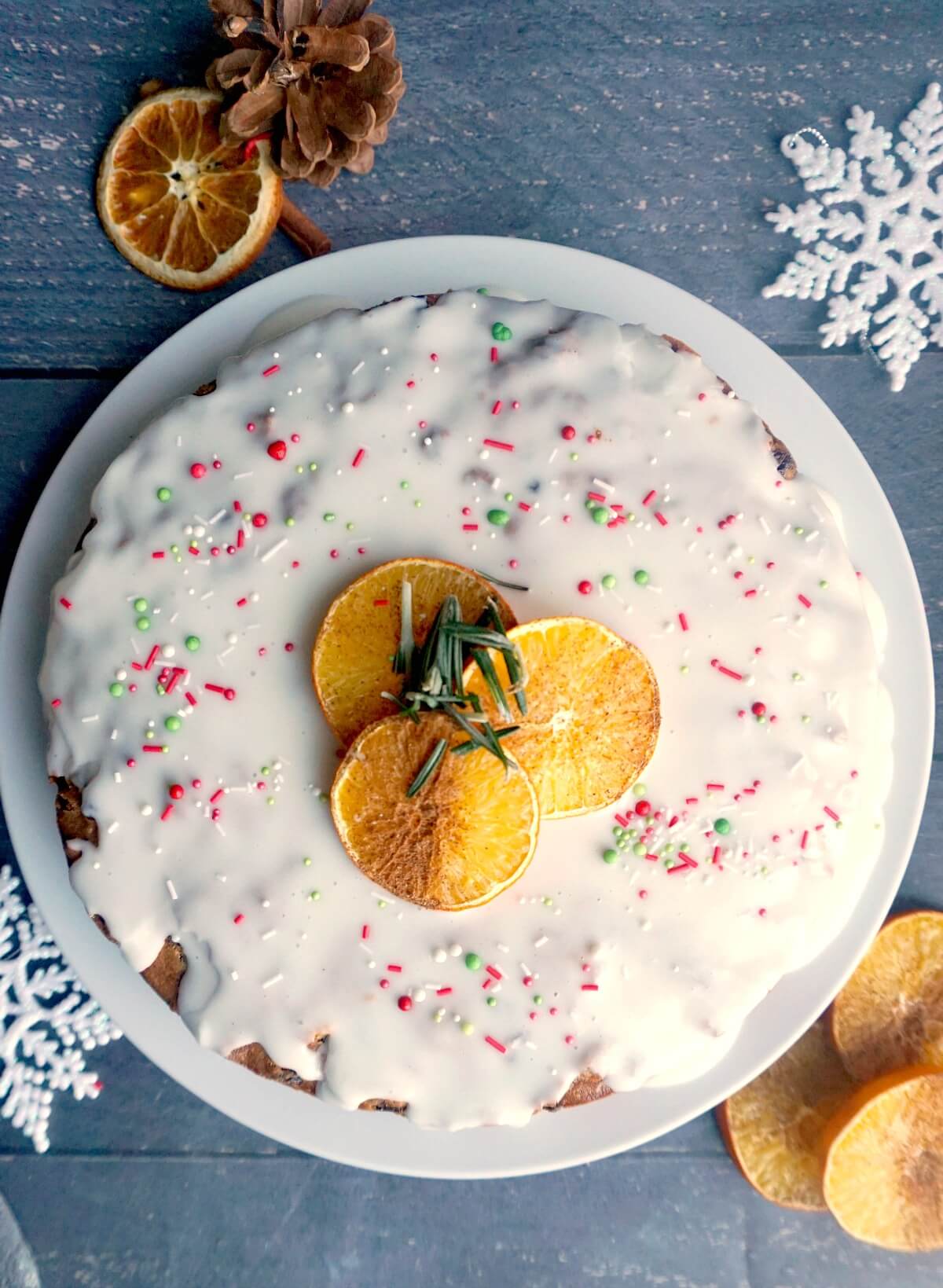 Overhead shoot of a Christmas cake with icing on top and 3 slices of orange