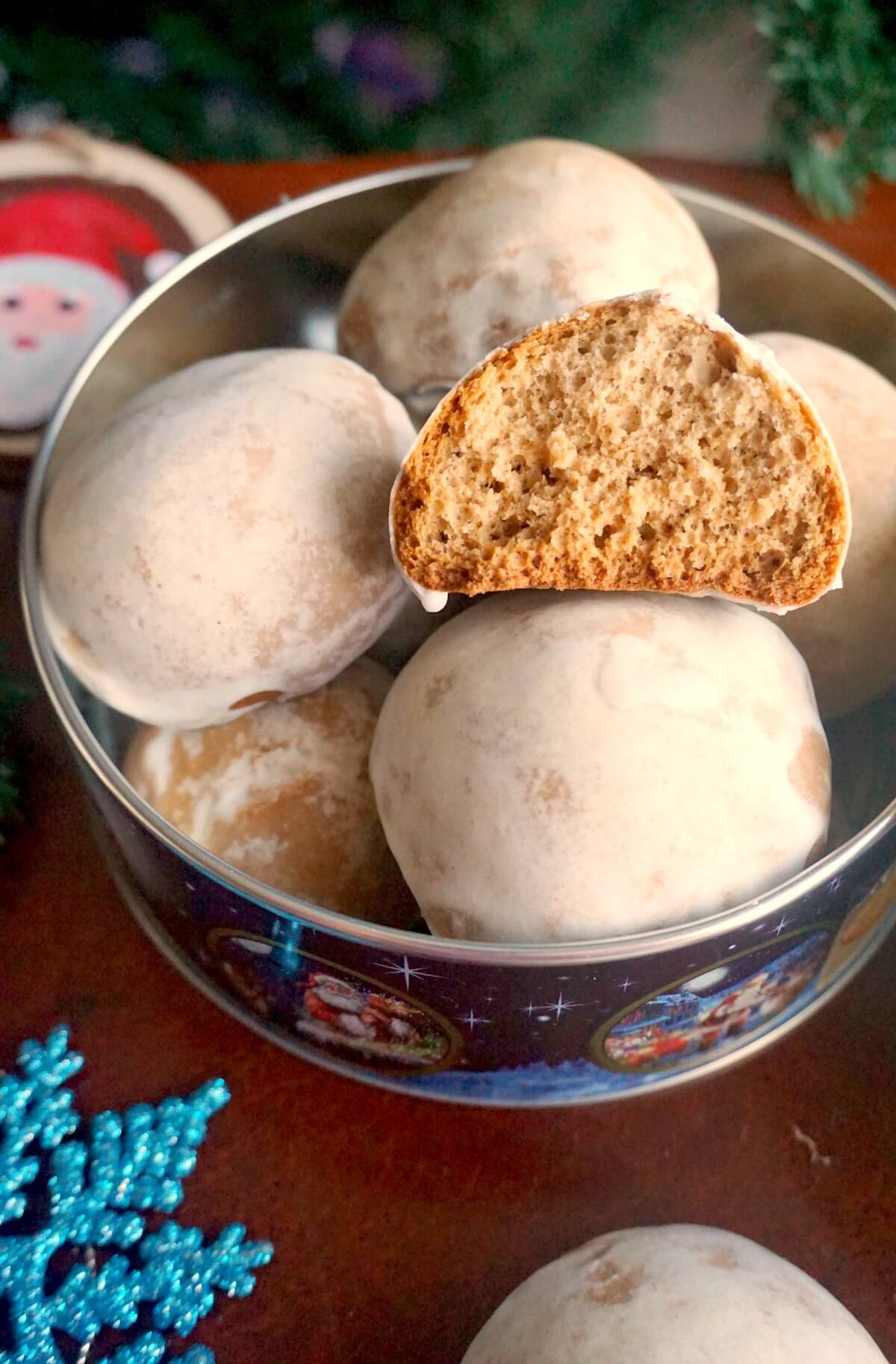 Half of a lebkuchen on top of other whole cookies in a cookie tin