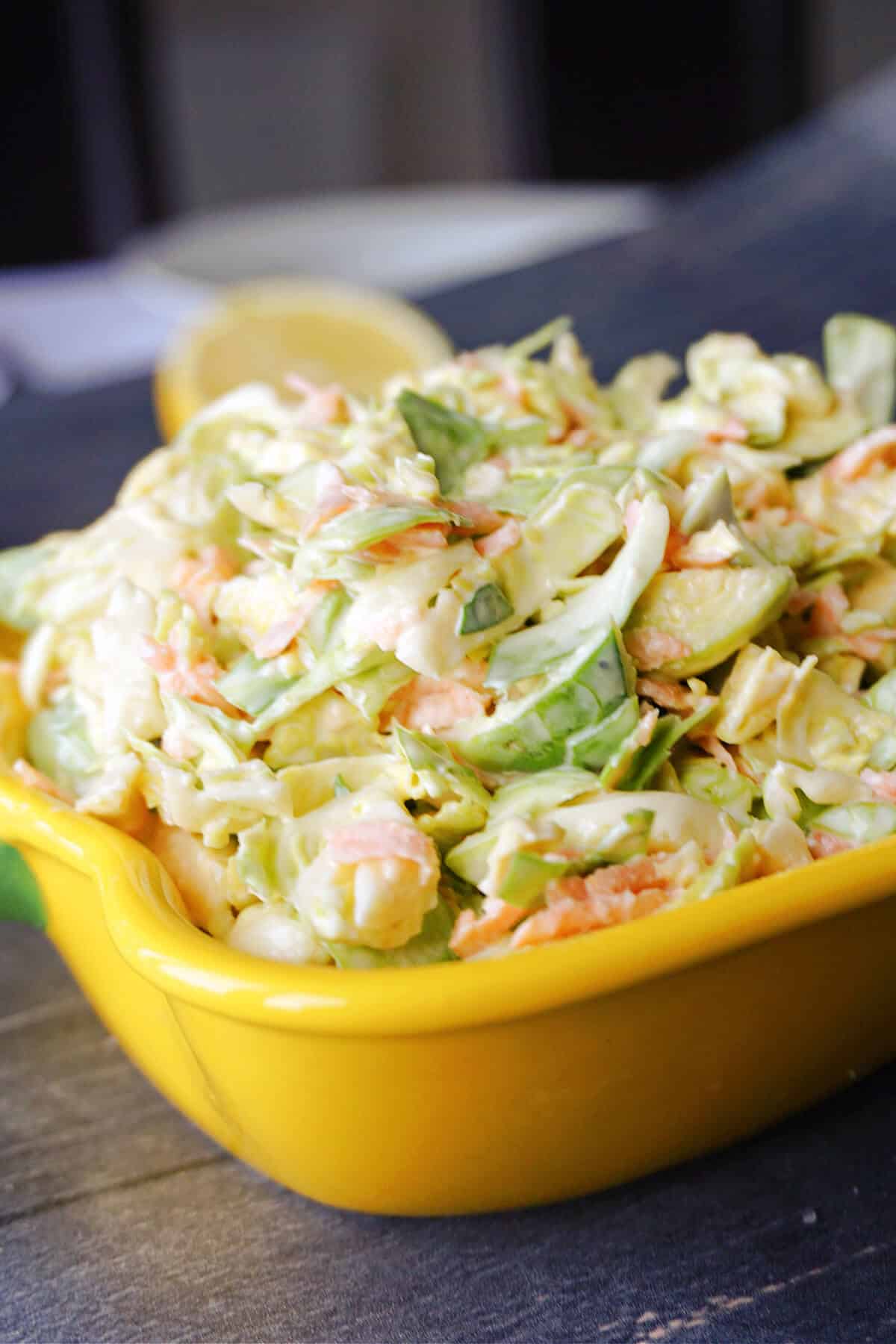 Close-up shoot of a yellow dish with brussel sprout slaw.