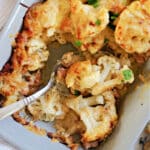 Close-up shot of a dish with cauliflower cheese and a spoon