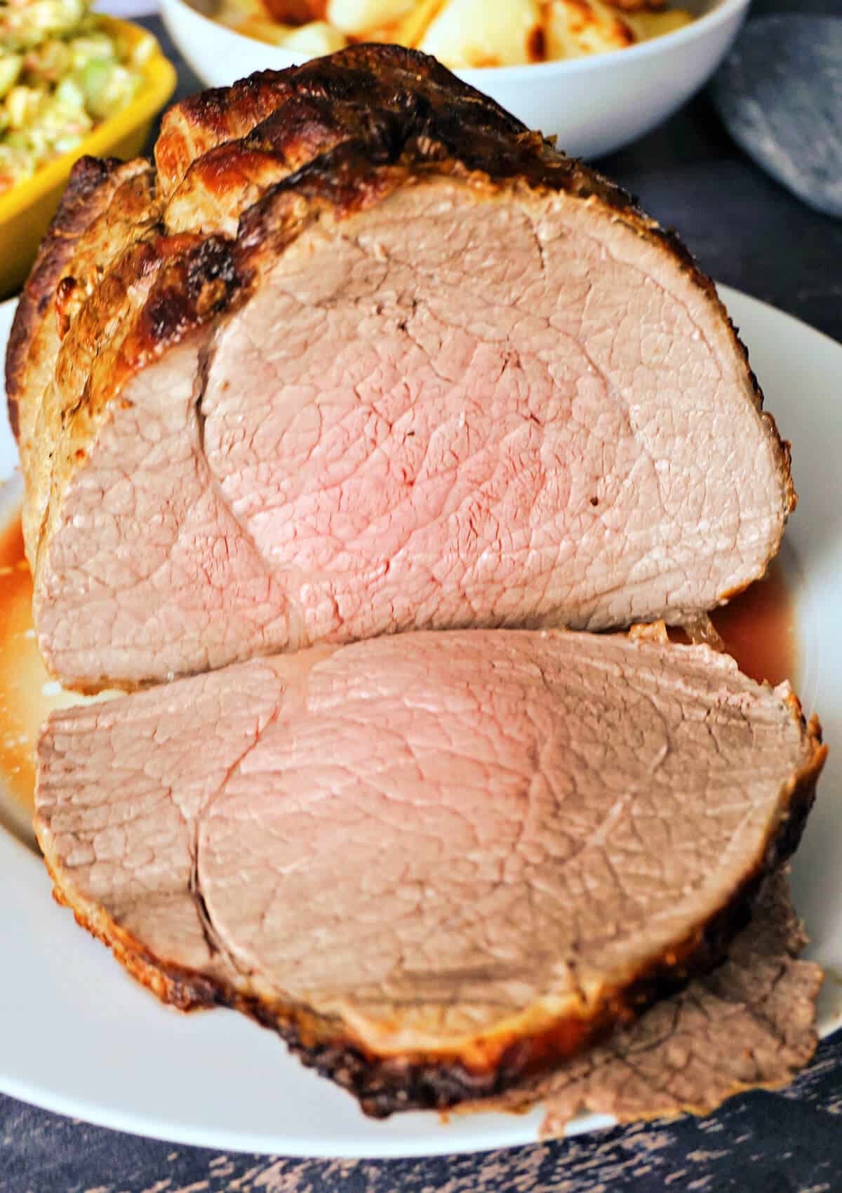 Close-up shoot of a roast joint on a white plate.