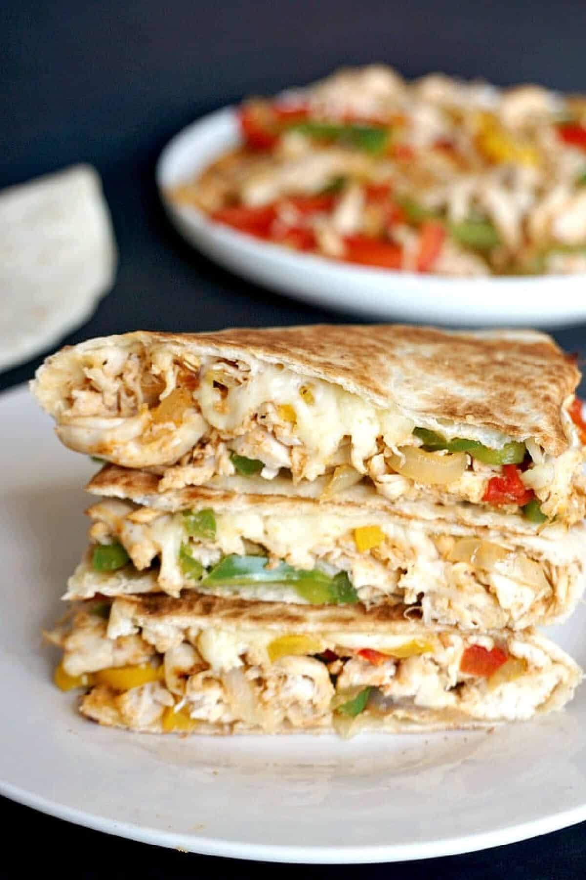 A stack of 3 quesadillas on a white plate