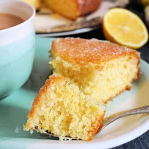 A slice of lemon drizzle cake on a light blue plate