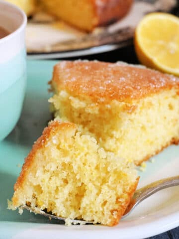 A slice of lemon drizzle cake on a light blue plate