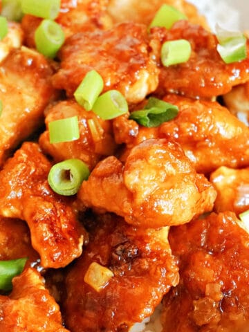 Close-up shoot of orange chicken pieces on a bed or rice