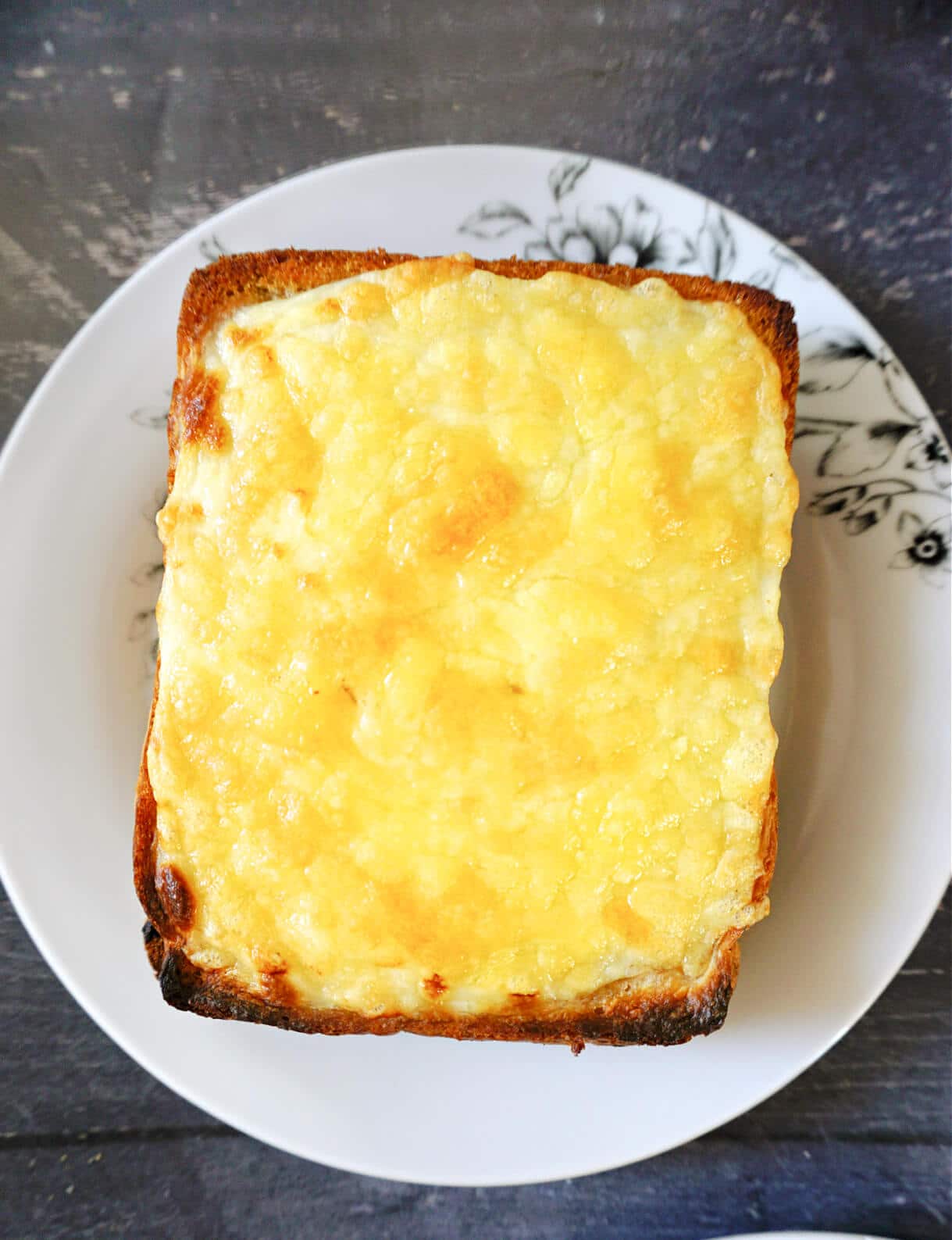 Overhead shot of a piece of croque monsieur on a white plate.