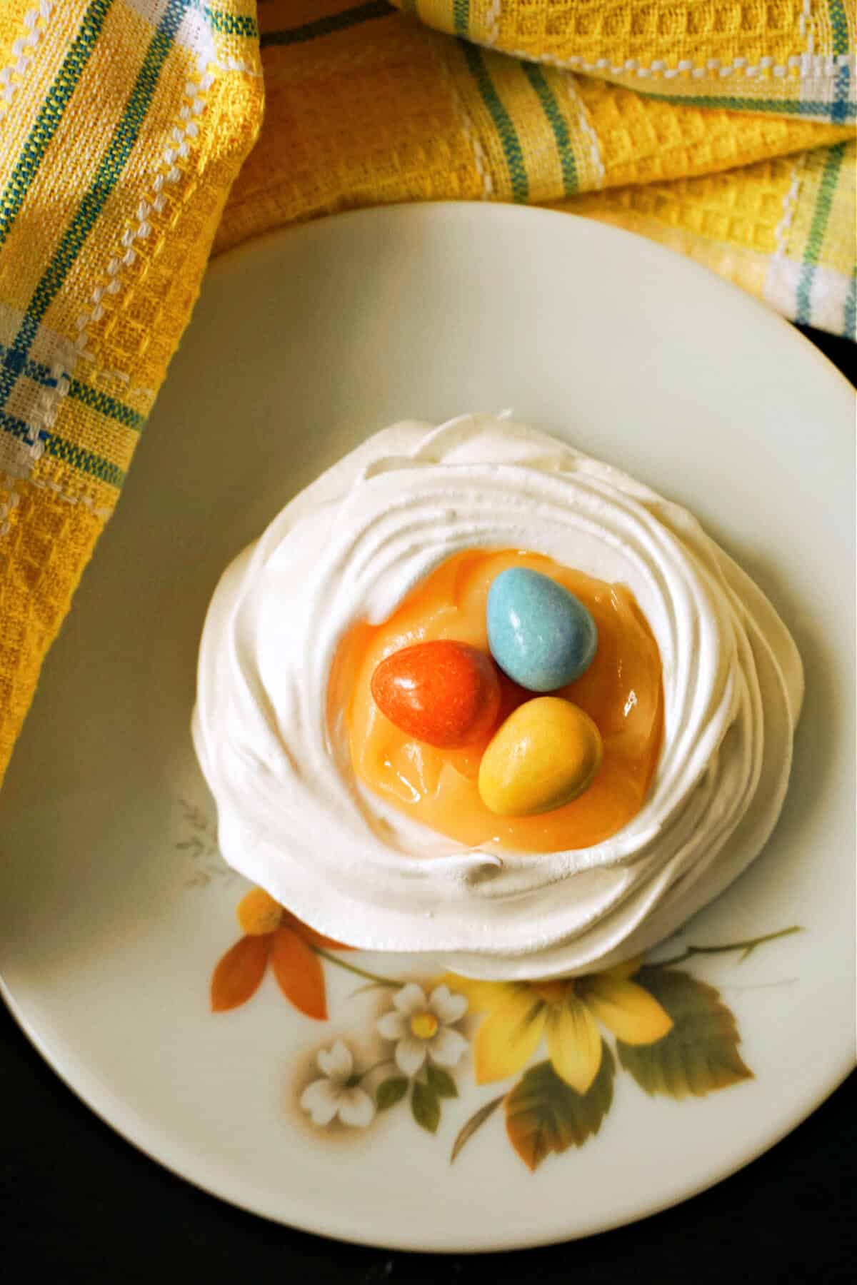 A meringue nest filled with lemon curd and topped with 3 chocolate eggs.