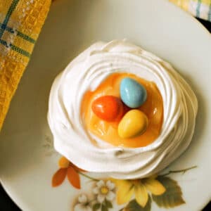 A meringue nest with lemon curd and 3 mini eggs.