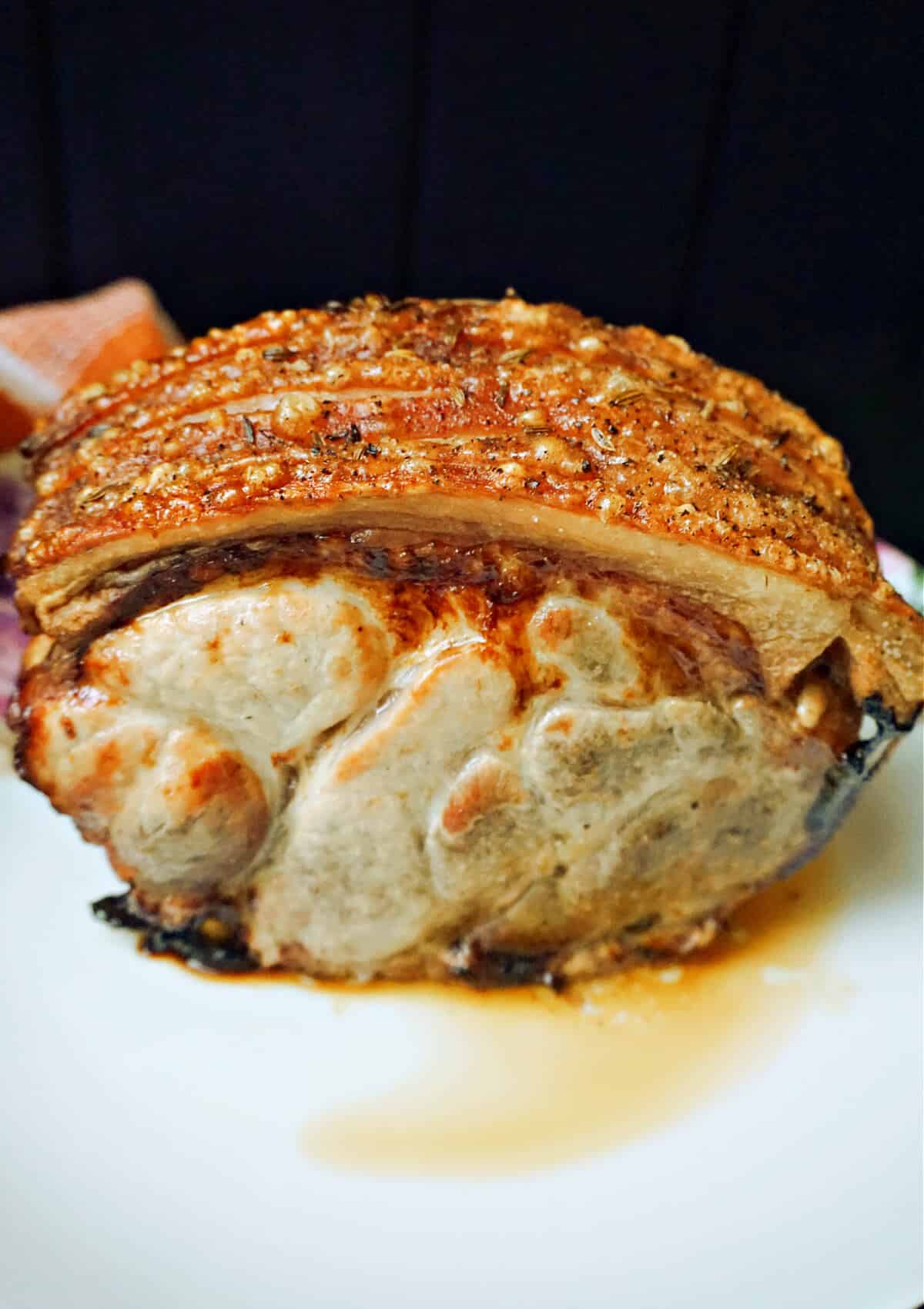 A piece of roast pork on a plate.