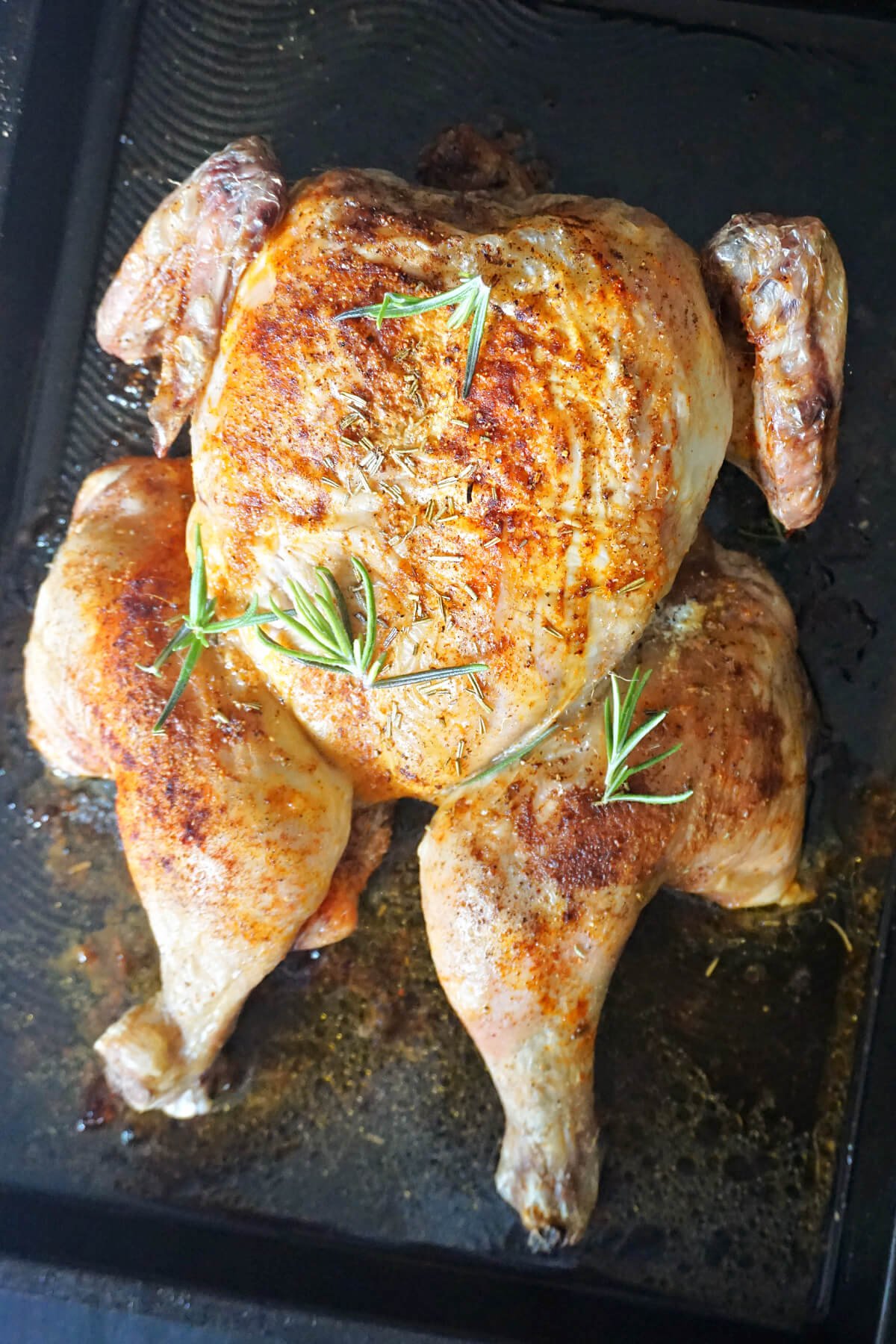 A spatchcock chicken on a roasting tray.