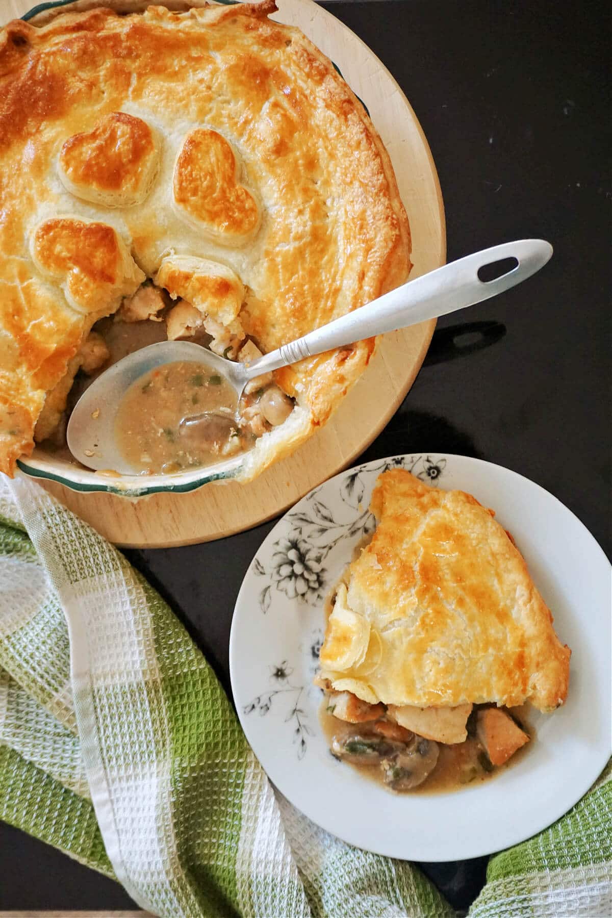 A white plate with a serving of pie and a dish with more pie.