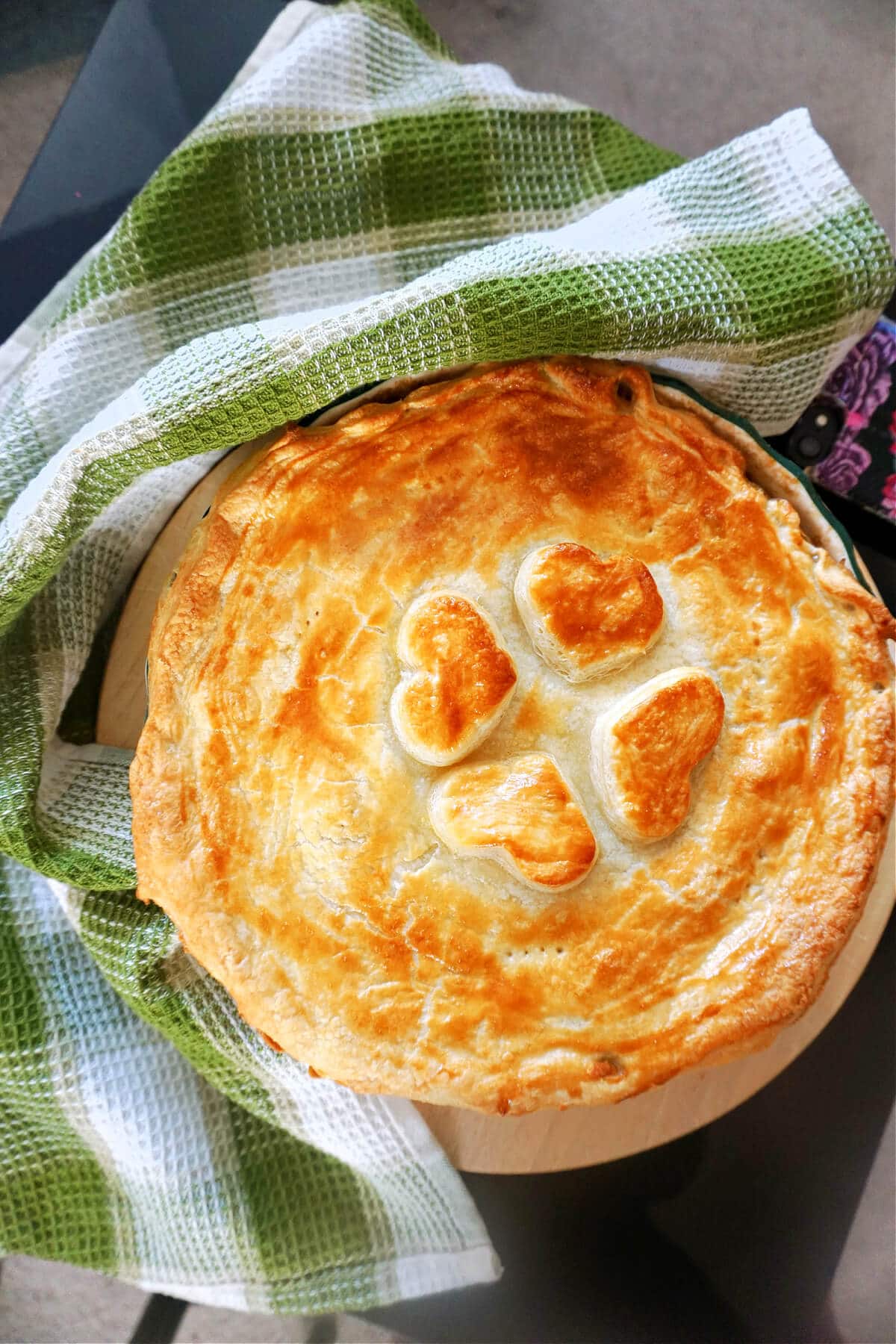 A pie with a kitchen towel around it.