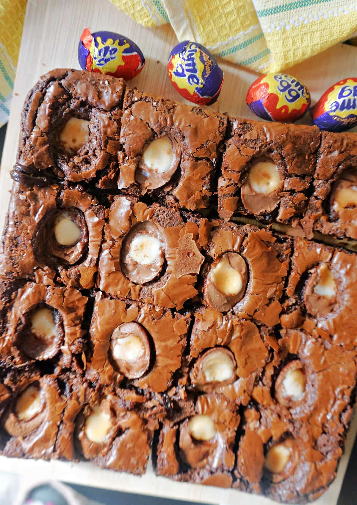 Close-up shoot of creme egg brownies on a wooden board.