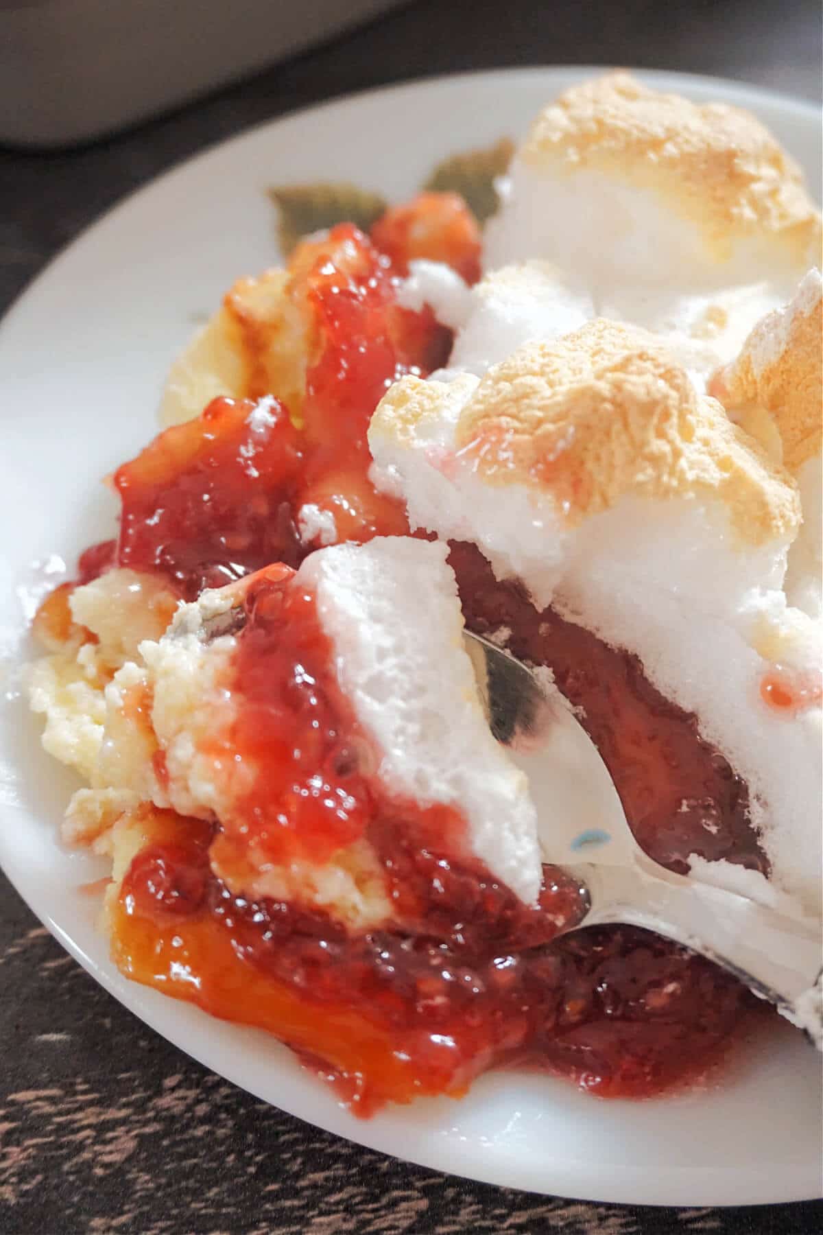 Close-up shot of a white plate with queen of puddings.