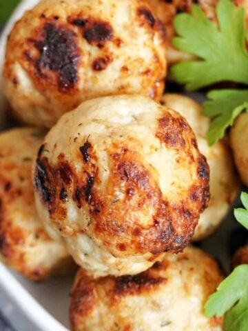 Close-up shot of meatballs garnished with parsley leaves