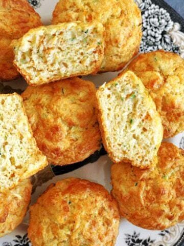 Close-up shot of 3 halves of a muffin on top of other whole muffins