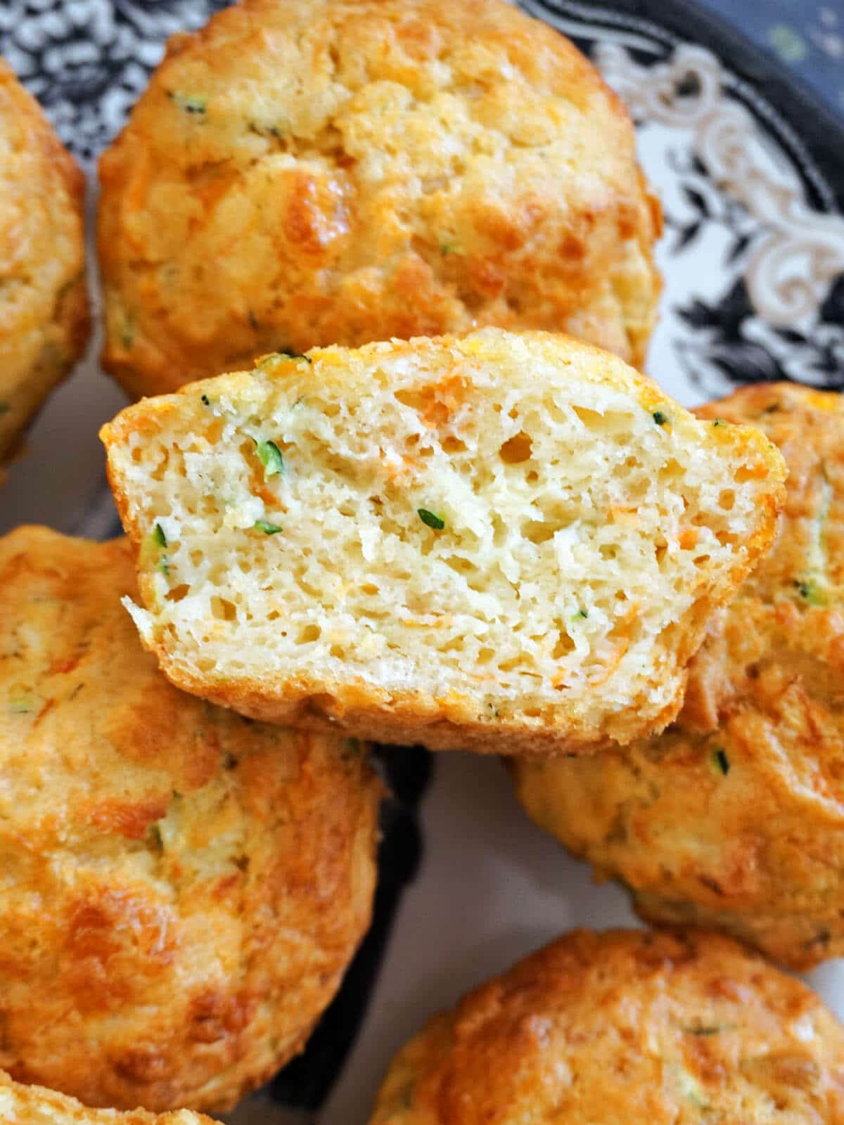 Overhead shot of half of a muffin on top of other whole muffins.