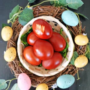 Overhead shoot of a small basket with red eggs around an Easter wreath.