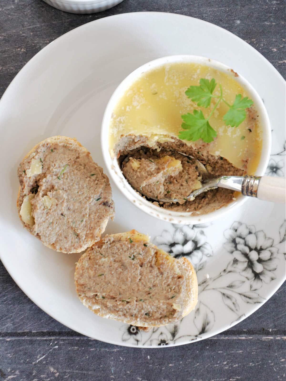 A ramekin with mushroom pate and 2 slices of bread with pate.