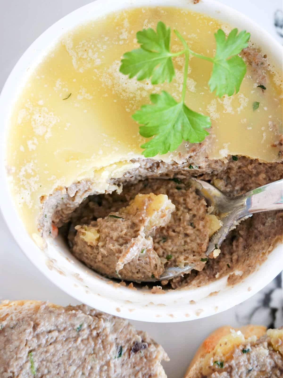 Close-up shot of a ramekin with mushroom pate garnished with fresh parsley leaves.