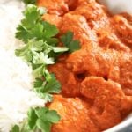 Close-up shot of butter chicken, rice and parsley