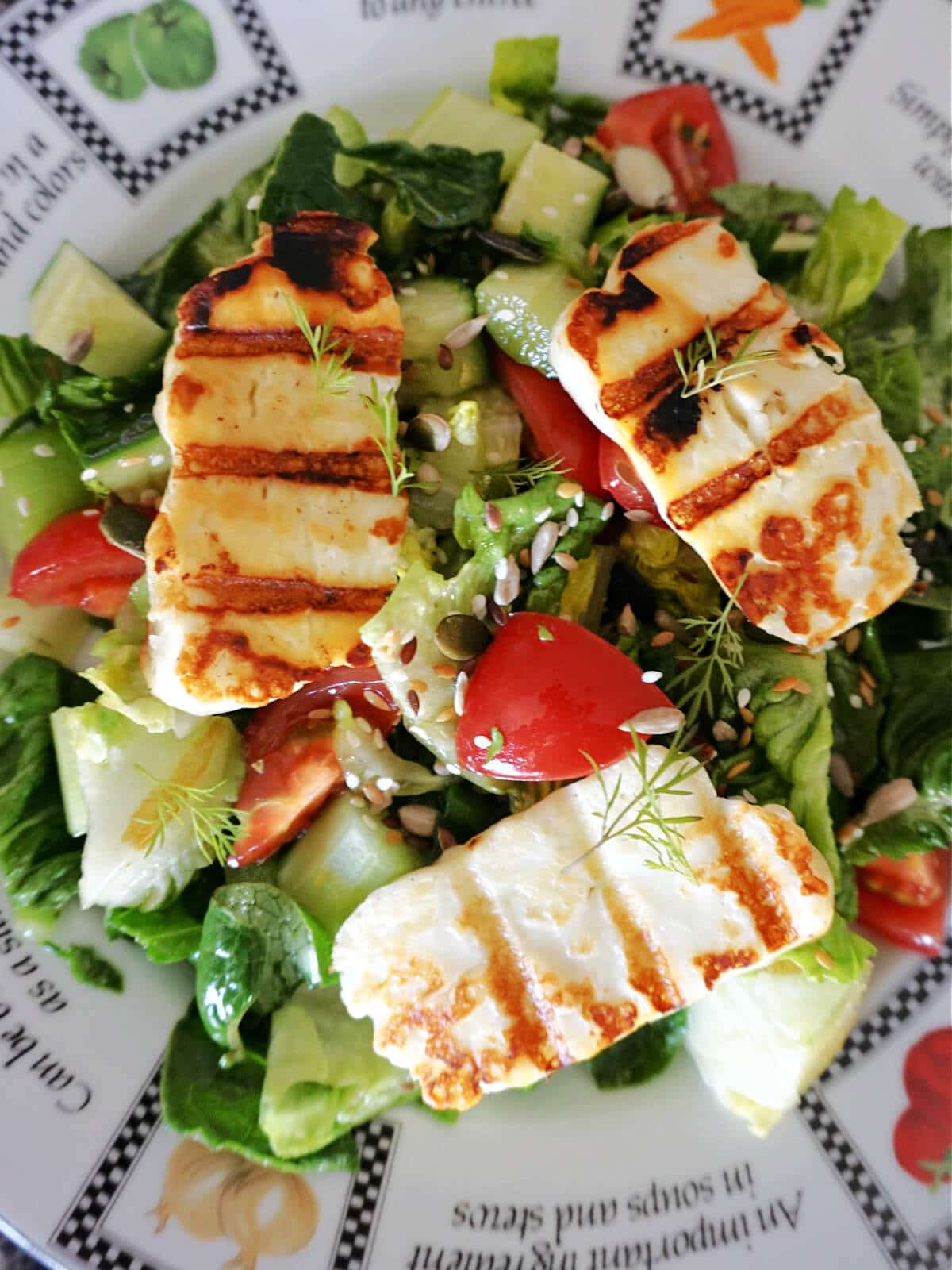 Close-up shot of a plate with grilled halloumi salad.