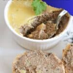 A round crostini spread with mushroom pate and a white ramekin with pate and a teaspoon in it.