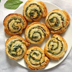 Overhead shoot of a white plate with 7 spinach and ricotta pinwheels