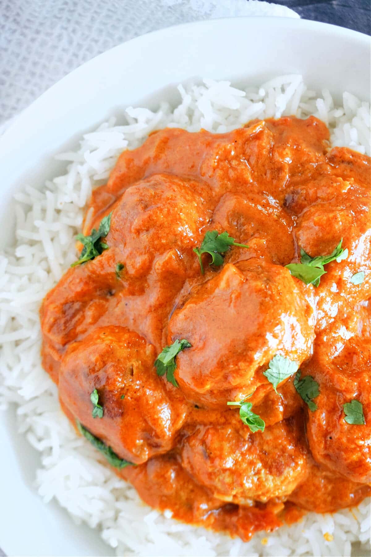 Overhead shot of a plate with rice topped with meatball in curry sauce.