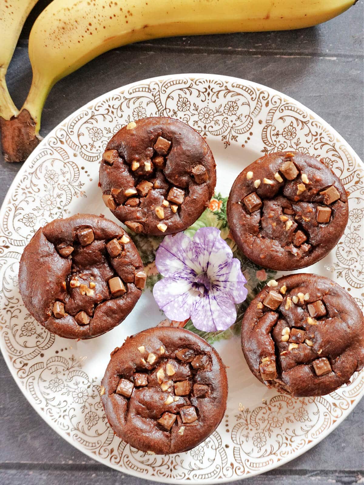 Overhead shot of a plate with 5 round brownies and a flower in the middle of the plate