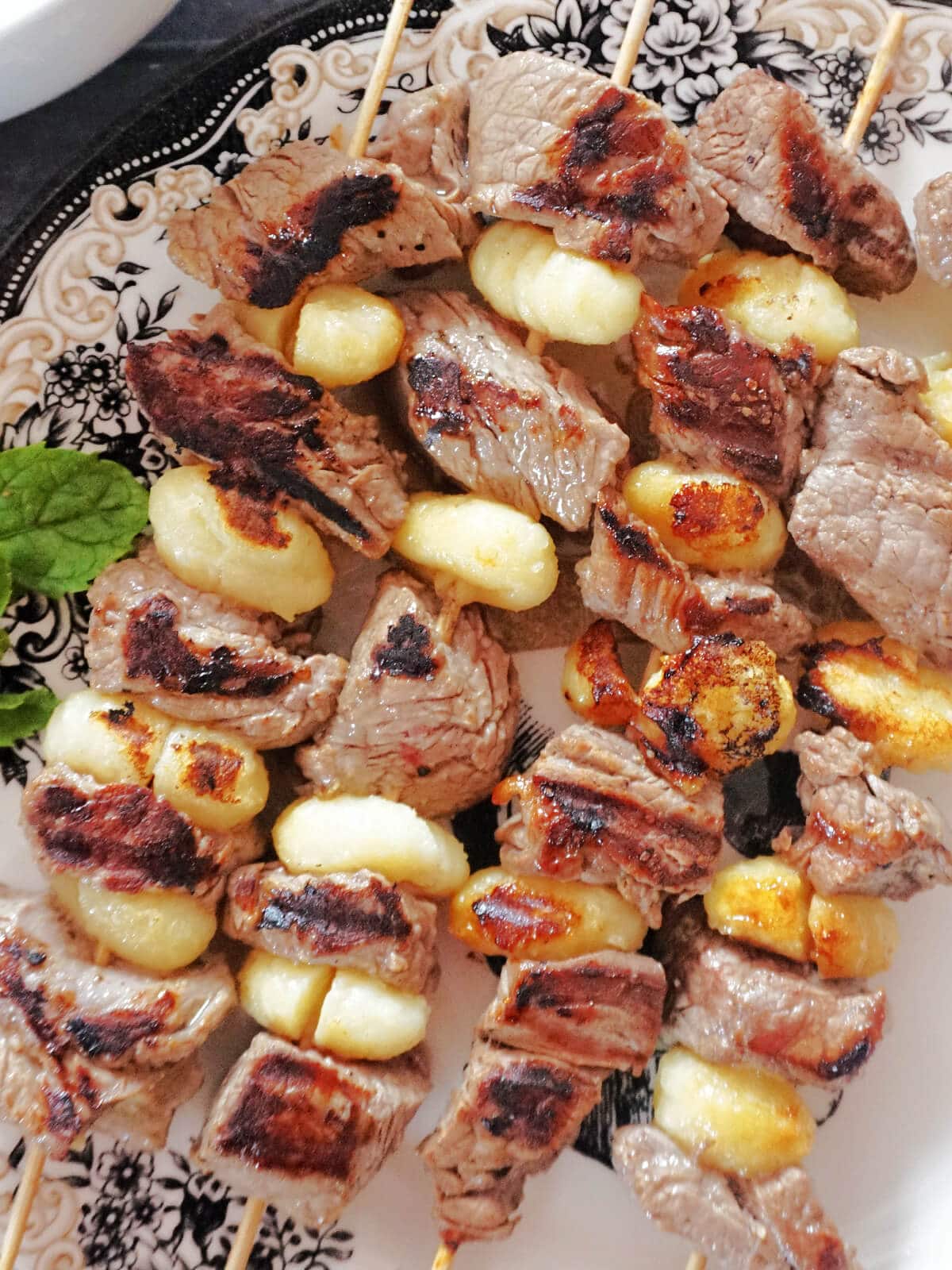 Close-up shot of 4 beef and gnocchi skewers.