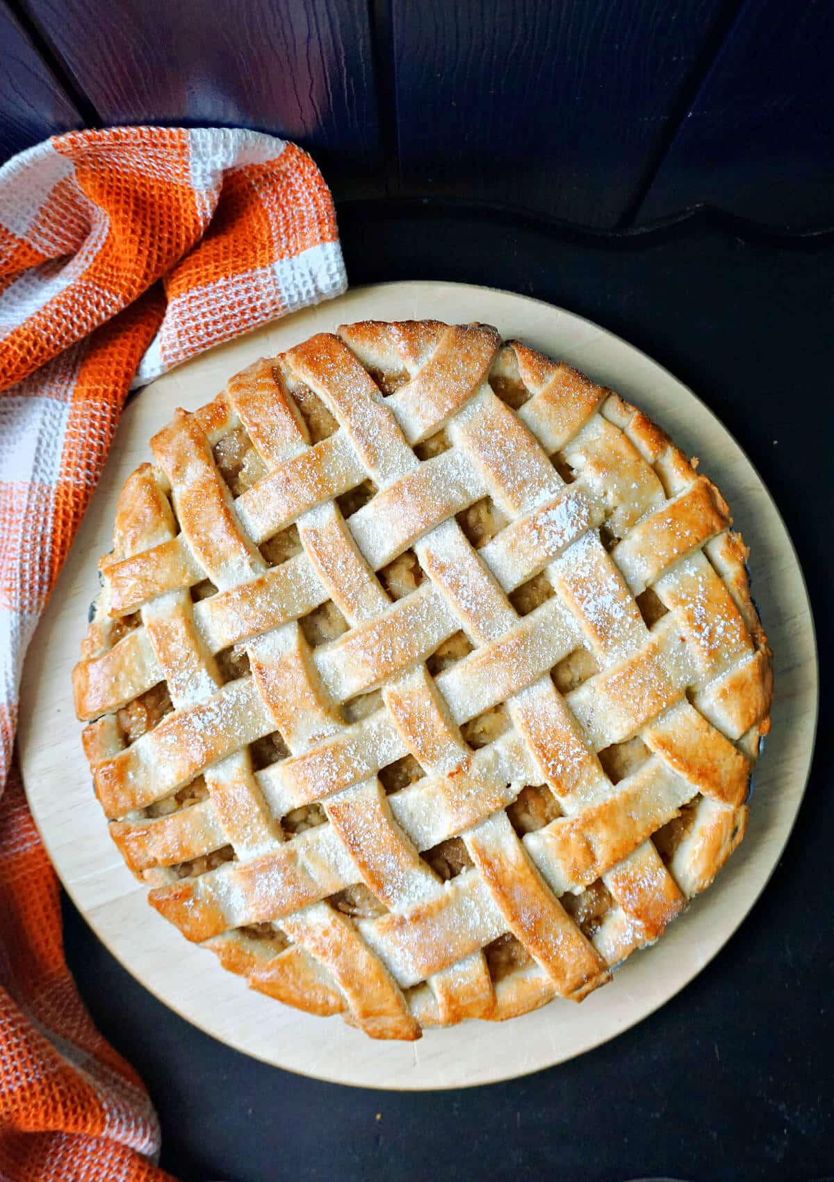 Overhead shoot of a lattice apple pie on a white plate.