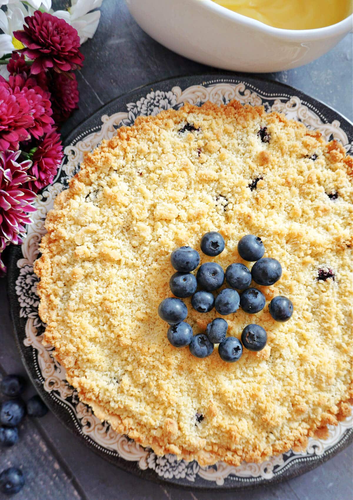 Overhead shot of a blueberry pie topped with blueberries.