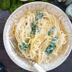 Overhead shot of a plate with spaghetti with spinach, ricotta and lemon