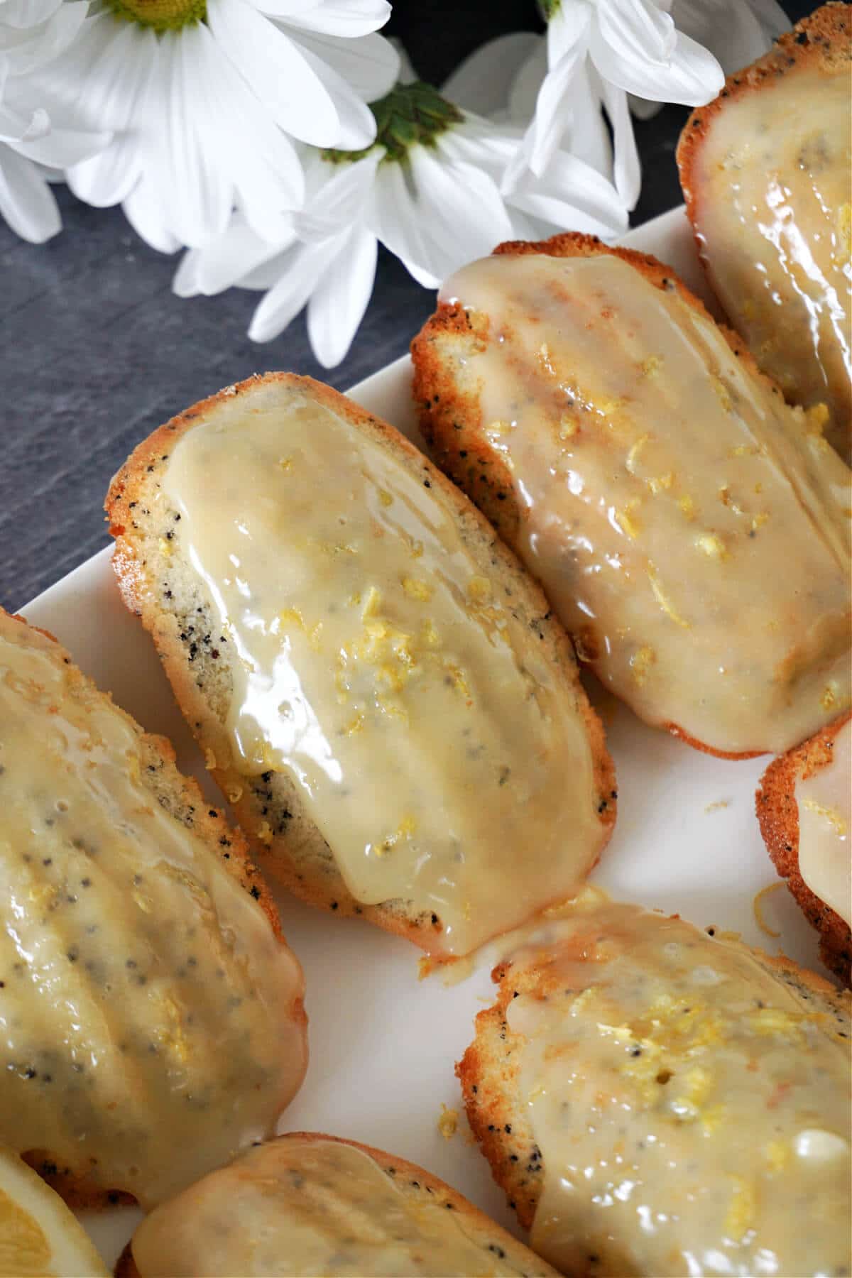 Close-up shot of madeleines on a white plate.