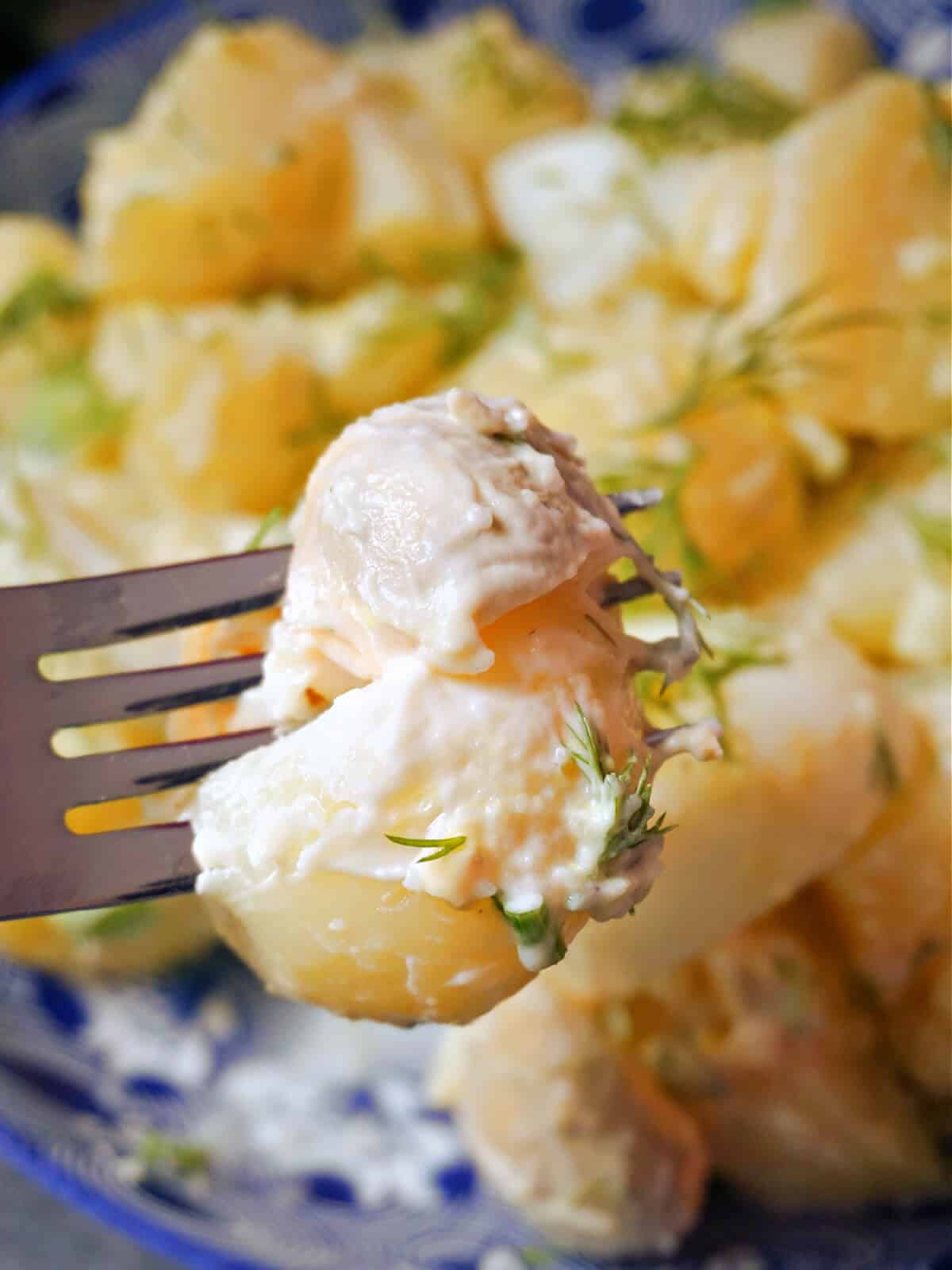Close-up shoot of a forkful of potato salad with eggs.