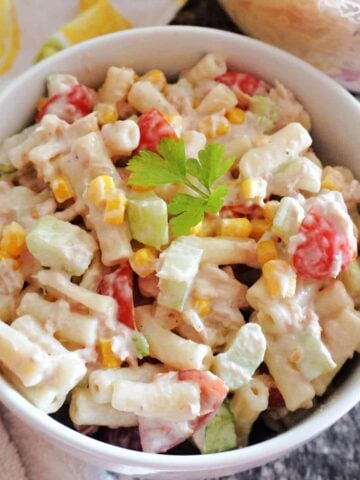 A white bowl with pasta salad with tuna and veggies