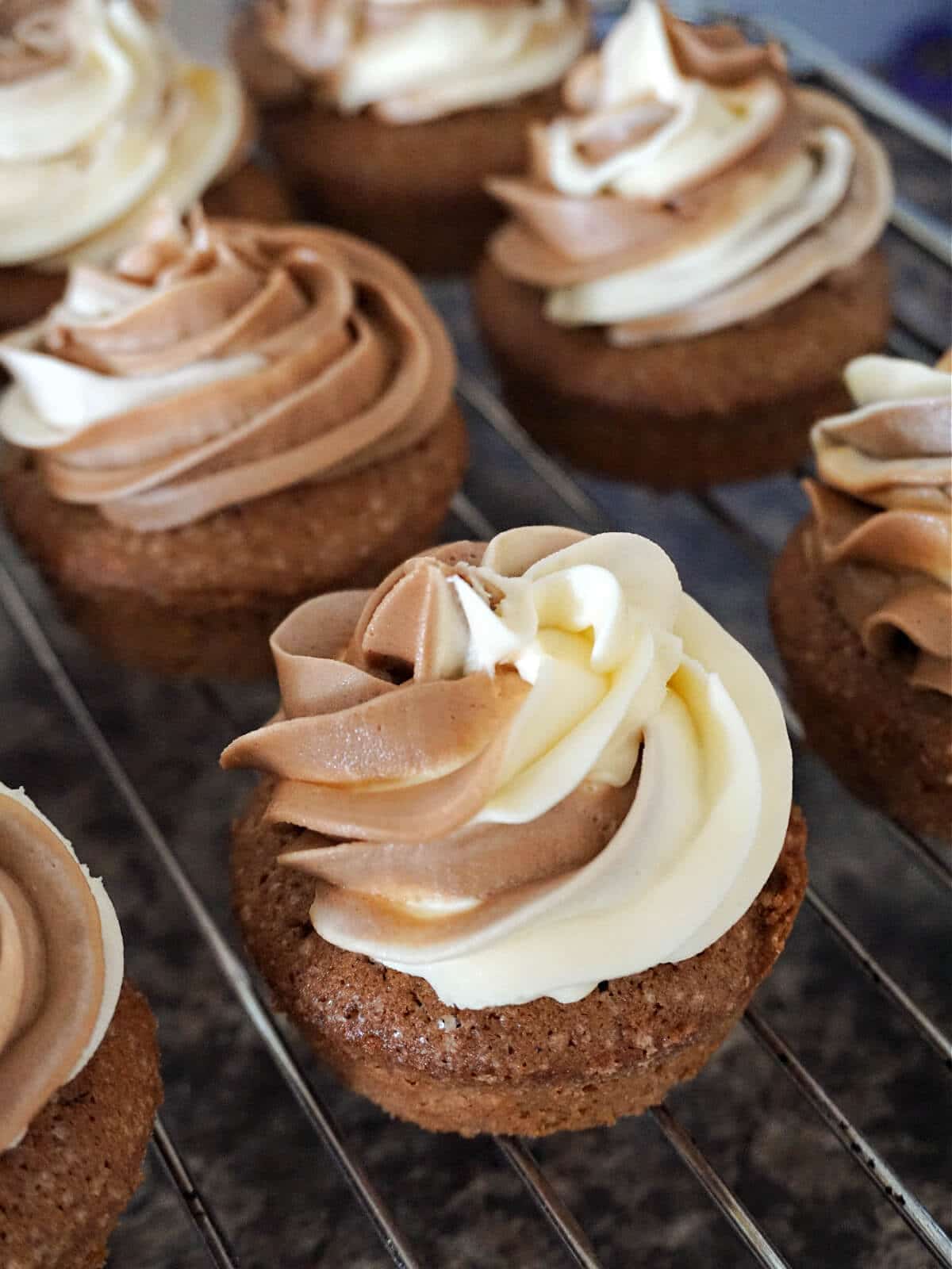 Cupcakes with marbled buttercream on a cooling rack