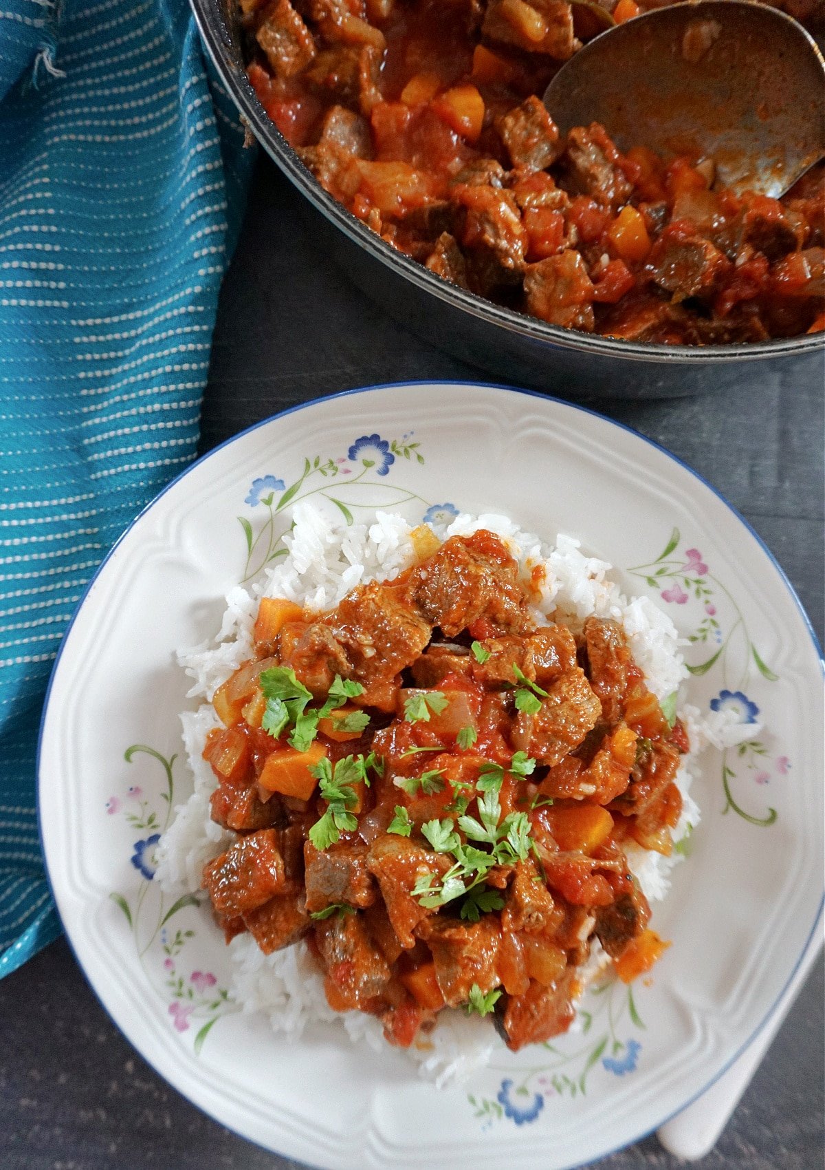 Overhead shot of a white plate with rice topped with beef chilli.