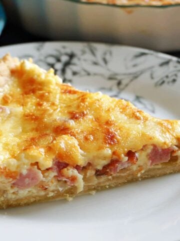 A slice of quiche on a white plate