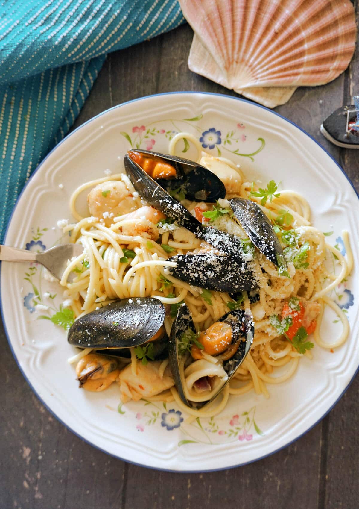 Overhead shot of a white plate with spaghetti and seafood.