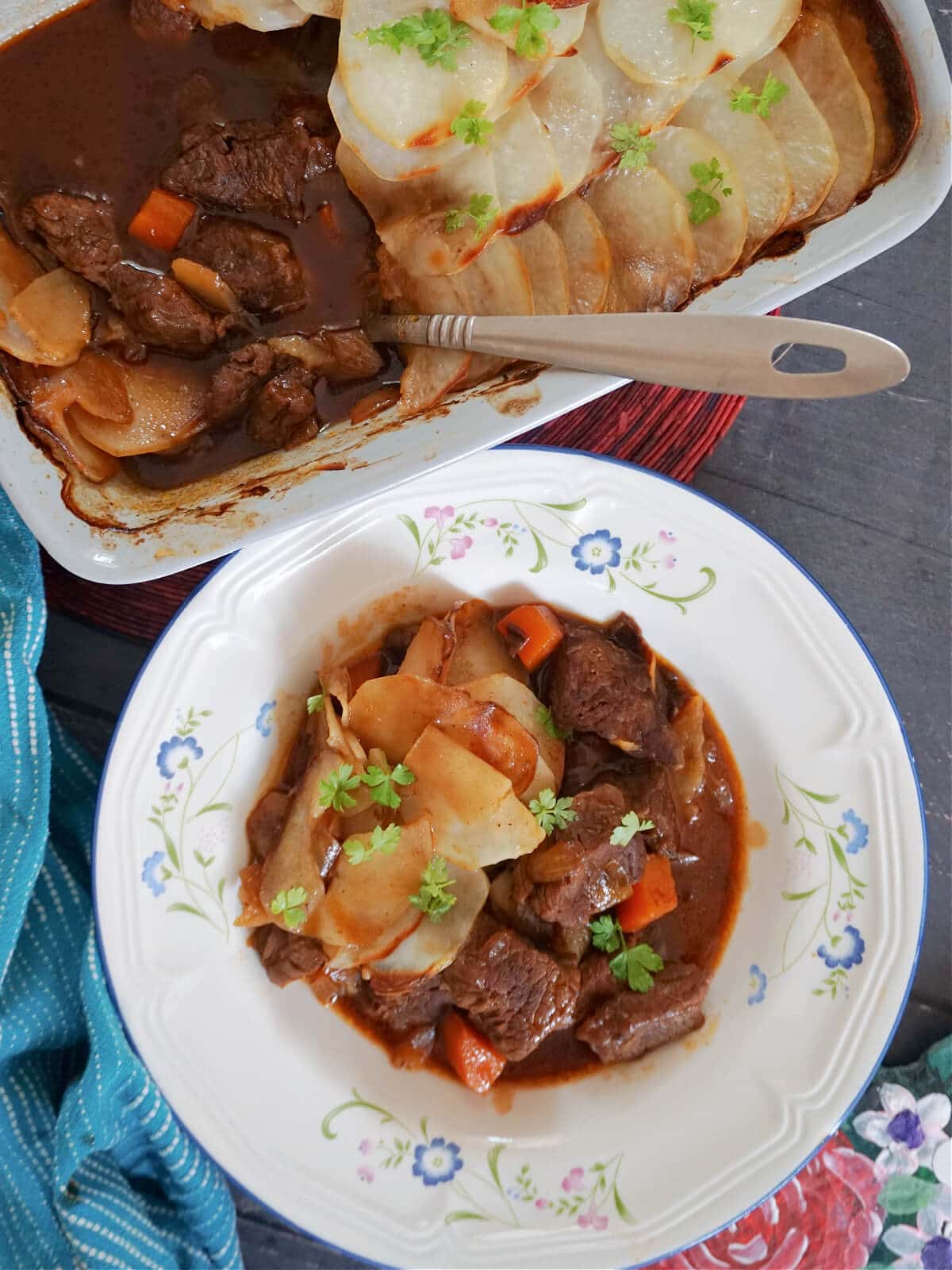 Overhead shot of a white plate with beef hot pot and a dish with more hotpot.