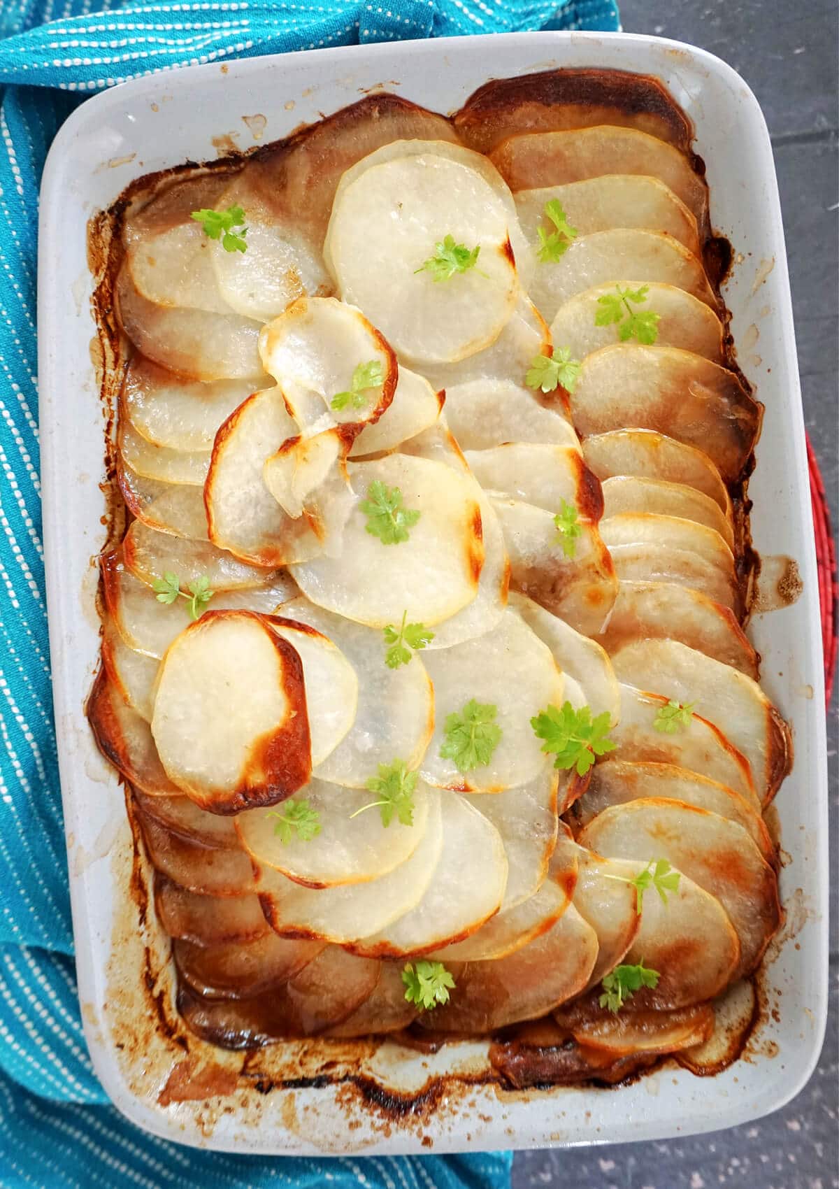 Overhead shot of a dish with  hotpot topped with sliced potatoes.